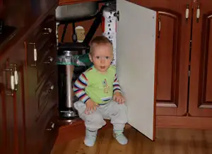 Adámek se usadil u odpadkového koše pod dřezem...